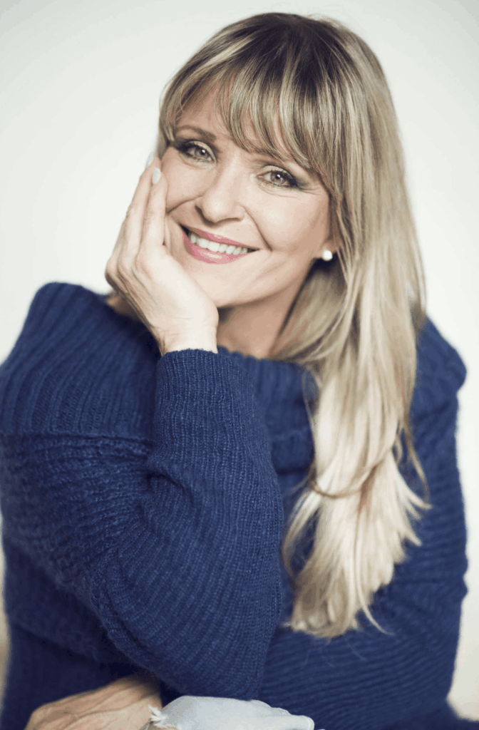 Portrait of a smiling actress and singer Chantal Poullain in a blue knitted sweater.